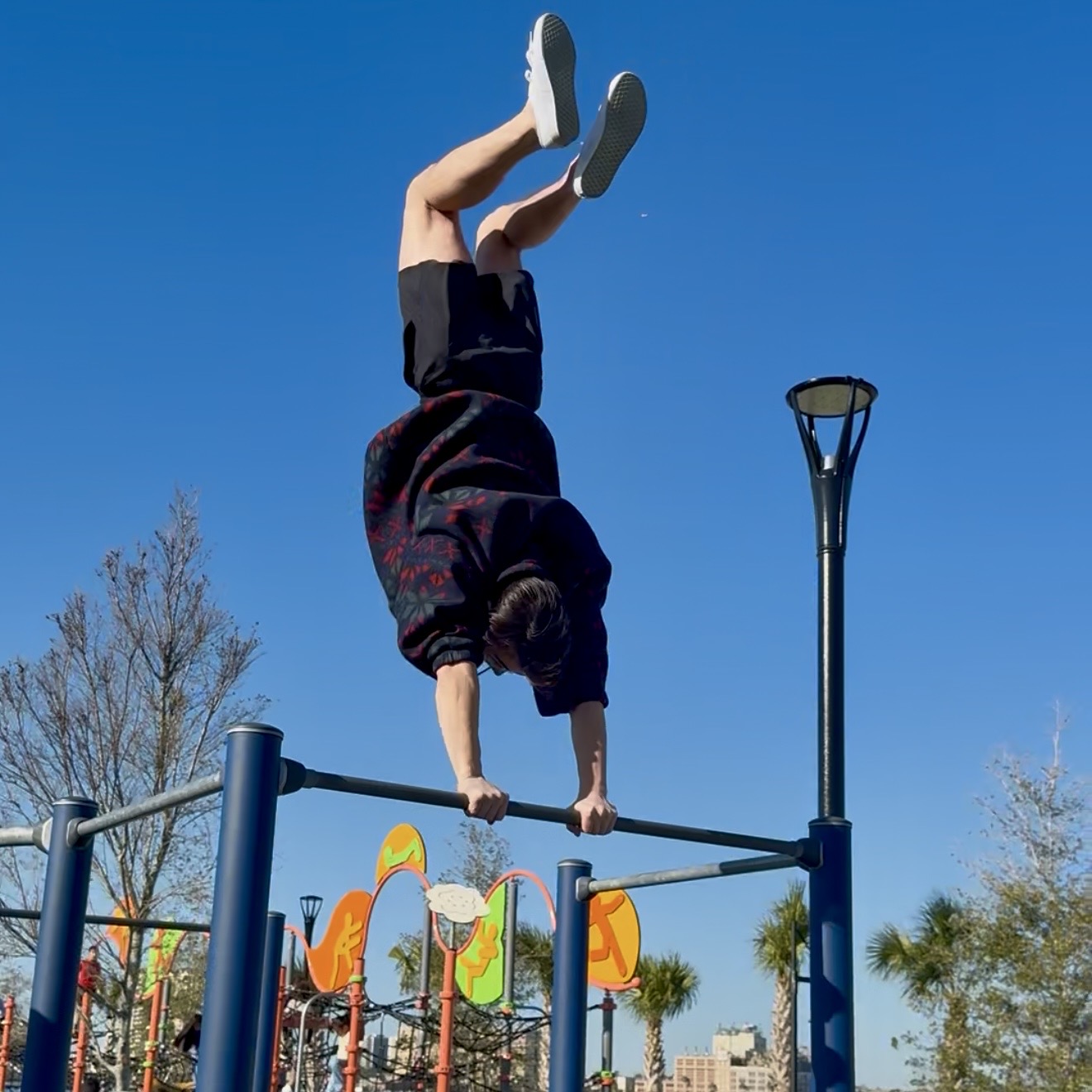JAXTHENX athlete holding a handstand on bars